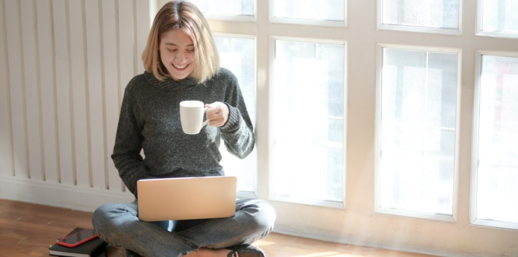 Woman drinking coffee with laptop